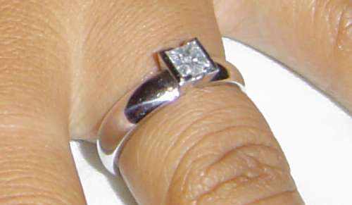 the engagement ring has a square diamond which tapers in where it meets the thick band